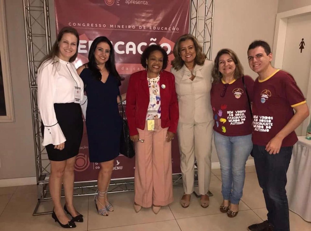 Palestrantes e organizadoras reunidas diante do painel do I Congresso Mineiro de Educação Fora da Caixa.