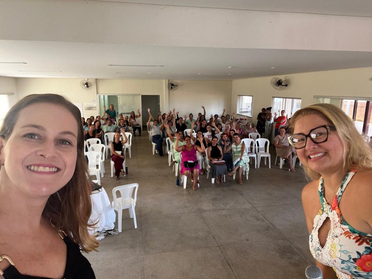 Lorena Lima e Débora Bessas com o auditório lotado de profissionais da rede municipal de Moema ao fundo.
